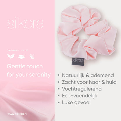 Promotieafbeelding van een grote Silkora premium scrunchie in lotus roze, met tekst over natuurlijke, ademende, vochtregulerende en eco-vriendelijke eigenschappen.