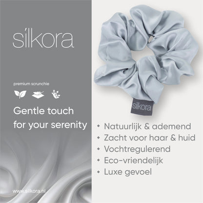 Promotieafbeelding van een grote Silkora premium scrunchie in zilvergrijs, met tekst over natuurlijke, ademende, vochtregulerende en eco-vriendelijke eigenschappen.