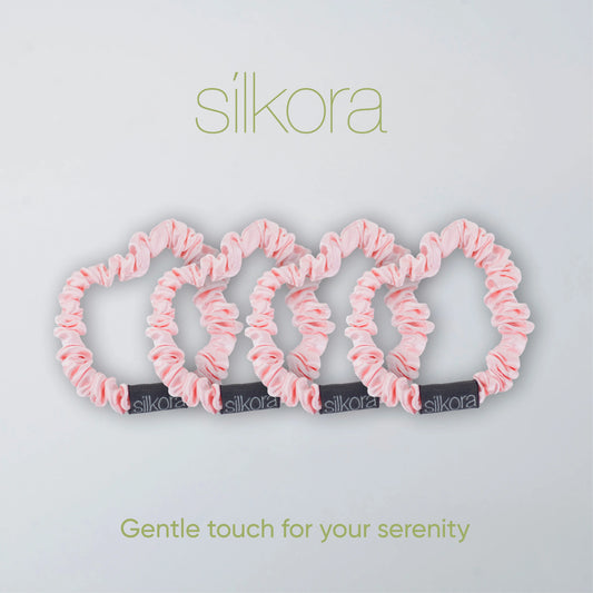 Vier kleine Silkora scrunchies in lotus roze op een lichte achtergrond met het Silkora-logo en de tekst "Gentle touch for your serenity".